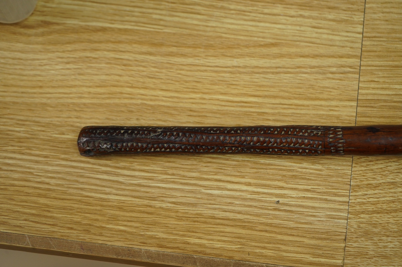 A 19th century Fiji carved hardwood throwing club, Ula, 40cm long, swollen head divided into nine segments, the handle carved with zigzag decoration and incised lines. Condition - good.